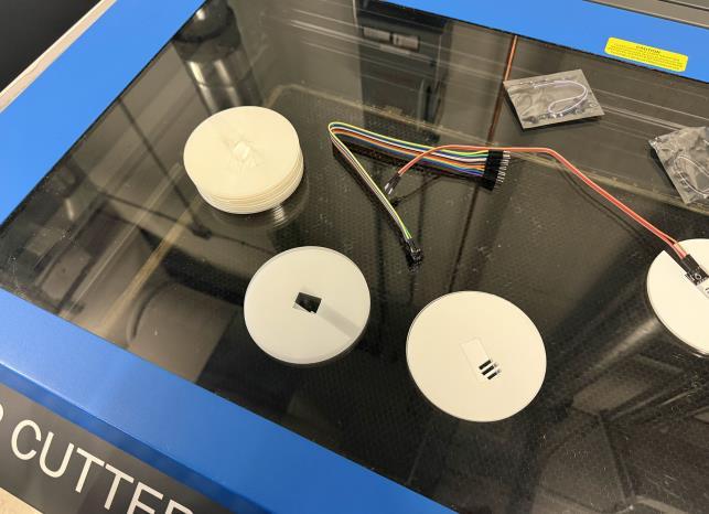 Acrylic coaster components tested on a laser cutter bed